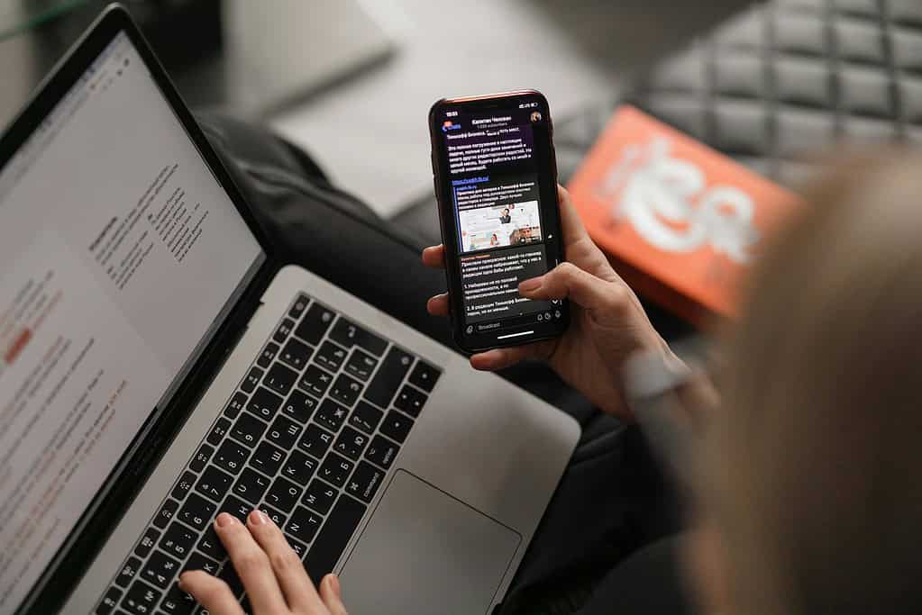 Person working on computer, checking phone